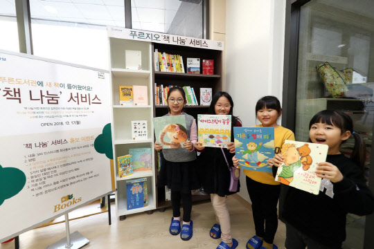 운정신도시 센트럴 푸르지오 입주 가정의 어린이들이 단지 내 UZ센터 푸른도서관에서 신간 도서를 들고 기념 사진을 찍고 있다.<대우건설 제공>